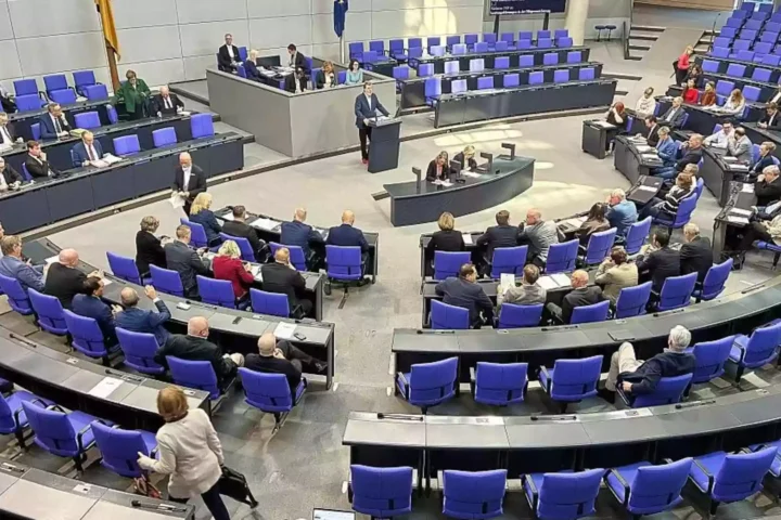 Blick in den Plenarsaal des Deutschen Bundestags mit Abgeordneten an den Plätzen und einer Person am Rednerpult.