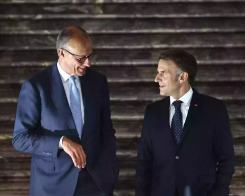 Friedrich Merz und Emmanuel Macron stehen nebeneinander und sprechen bei einem formellen Termin.