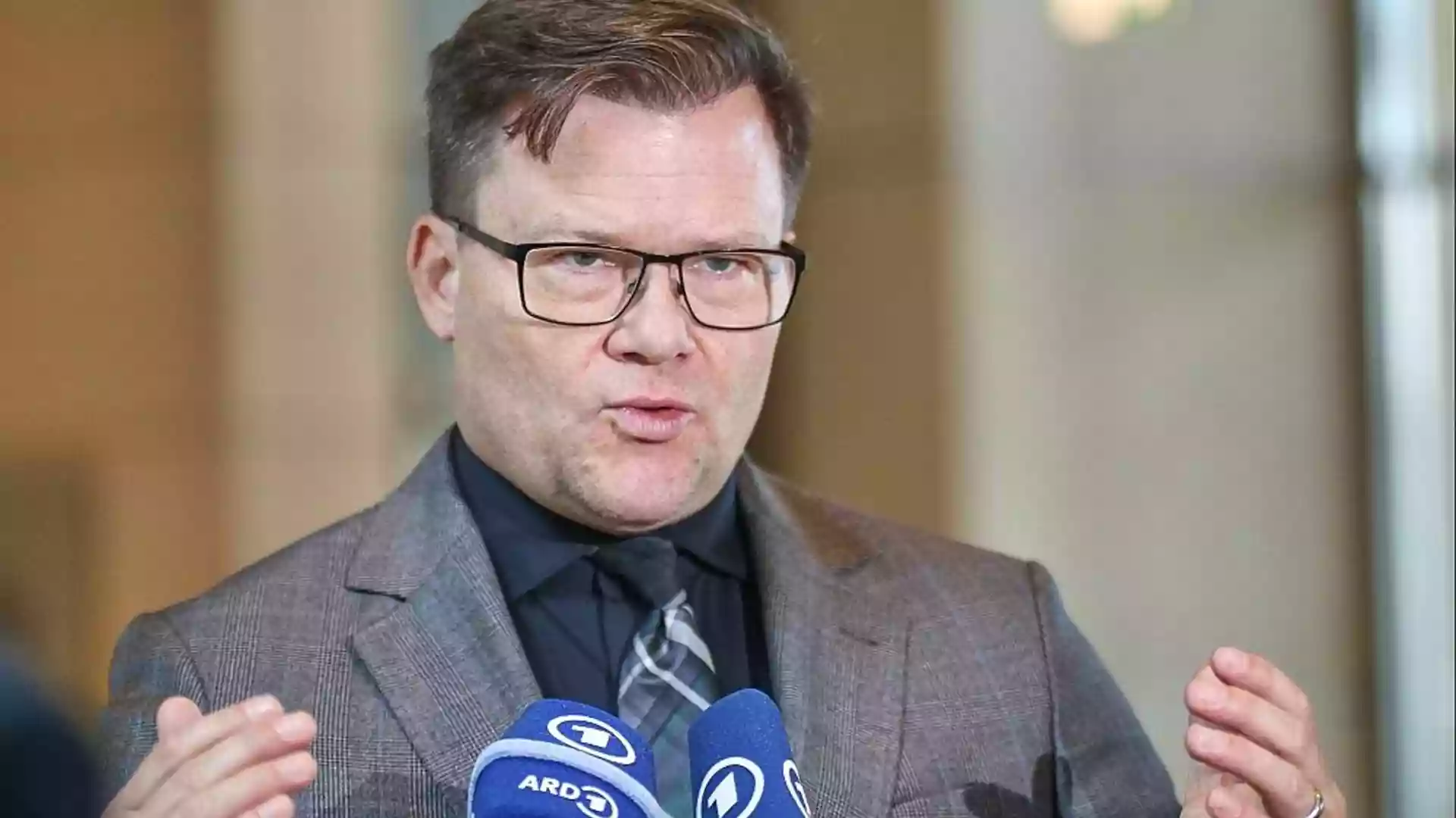 Carsten Schneider spricht vor Mikrofonen bei einer Presseäußerung.