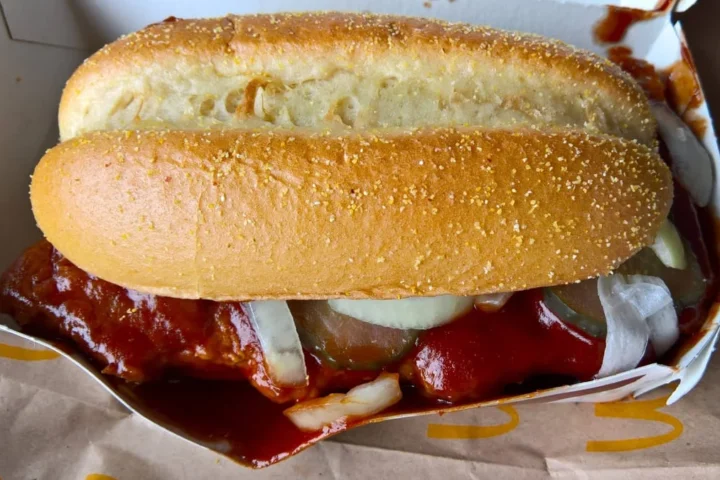 Ein McRib-Sandwich in einer McDonald’s-Verpackung, mit Barbecue-Sauce und Zwiebeln.