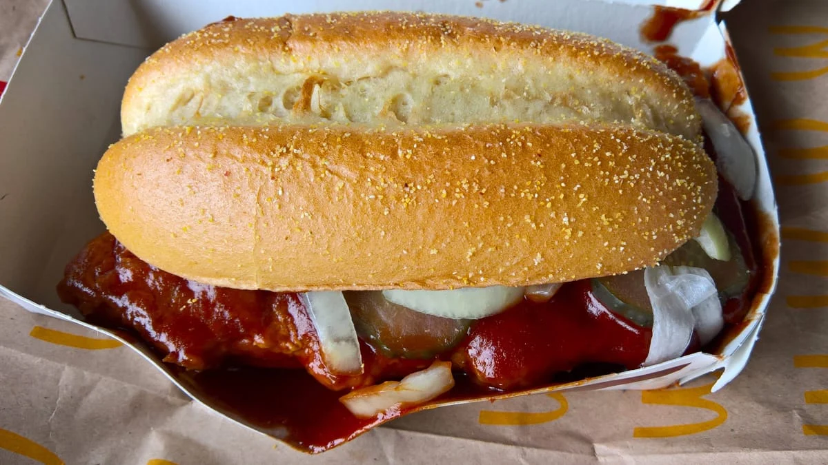 Ein McRib-Sandwich in einer McDonald’s-Verpackung, mit Barbecue-Sauce und Zwiebeln.